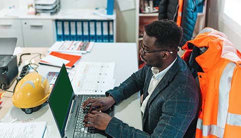 Black civil engineer planning project on laptop